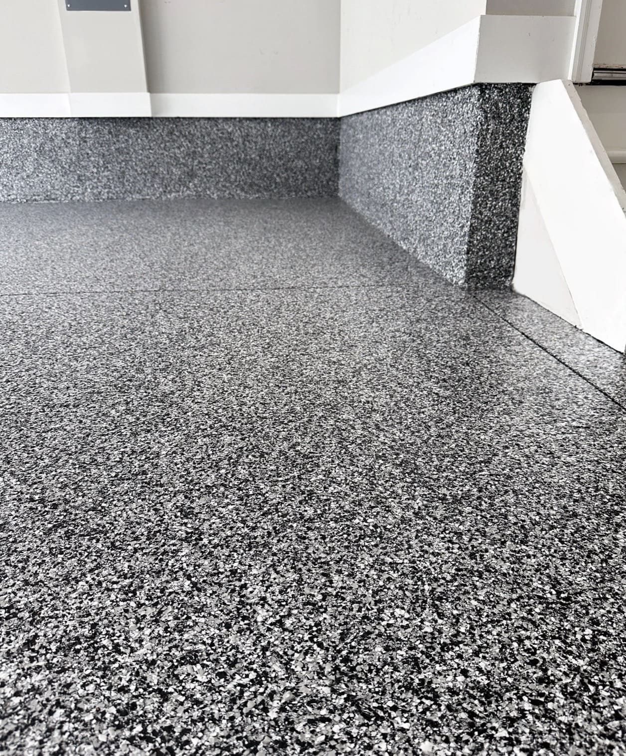 Grey flake epoxy floor with coved base detail by Titan Floor Systems